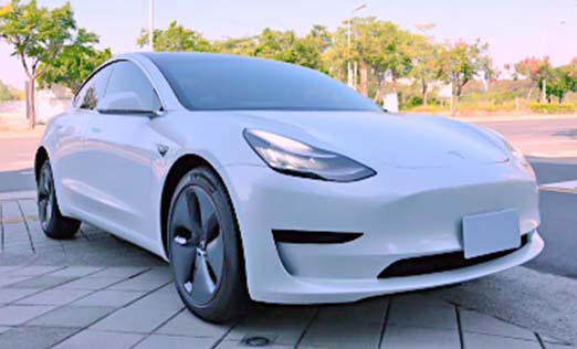 a white tesla model 3 that parking on the park