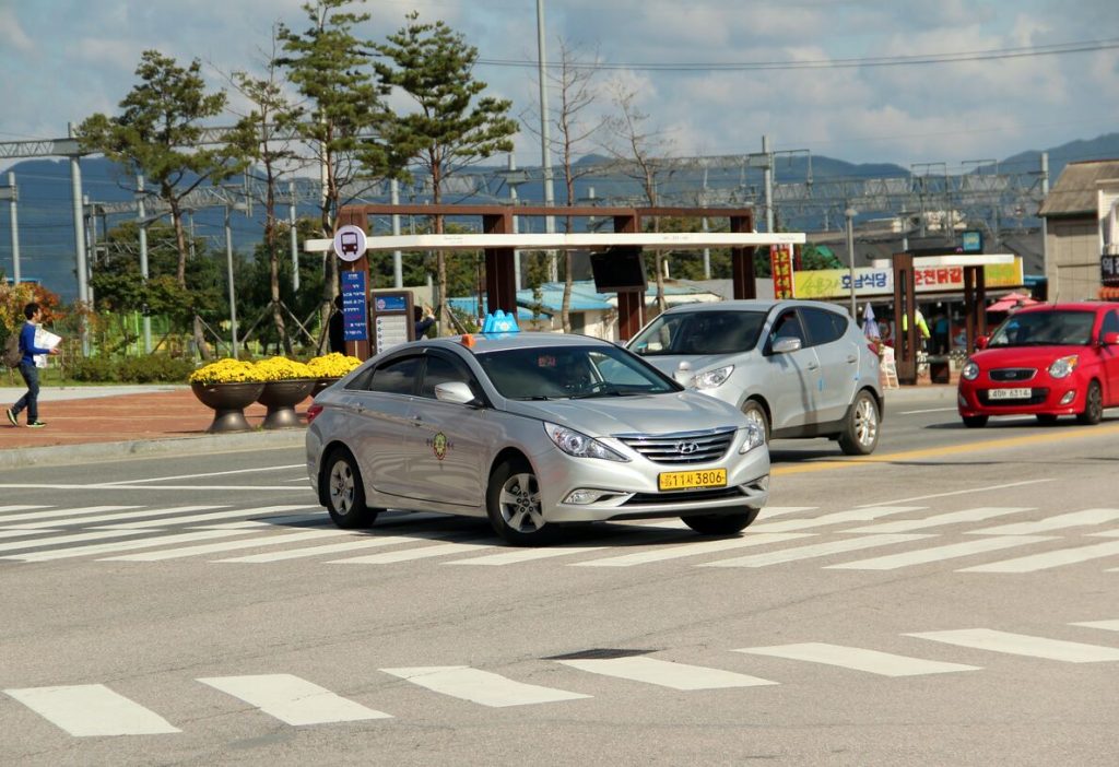一台銀色的現代，是一台首爾計程車，左轉於十字路口