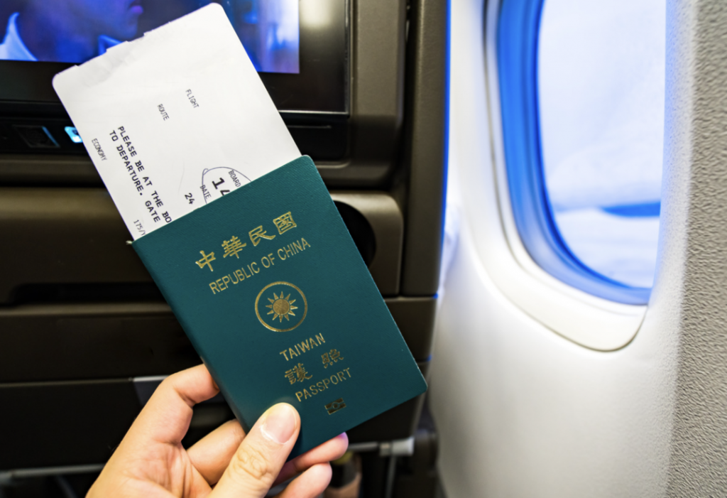 首爾自由行，一個男人坐在飛機上，手中拿著台灣護照，夾著機票