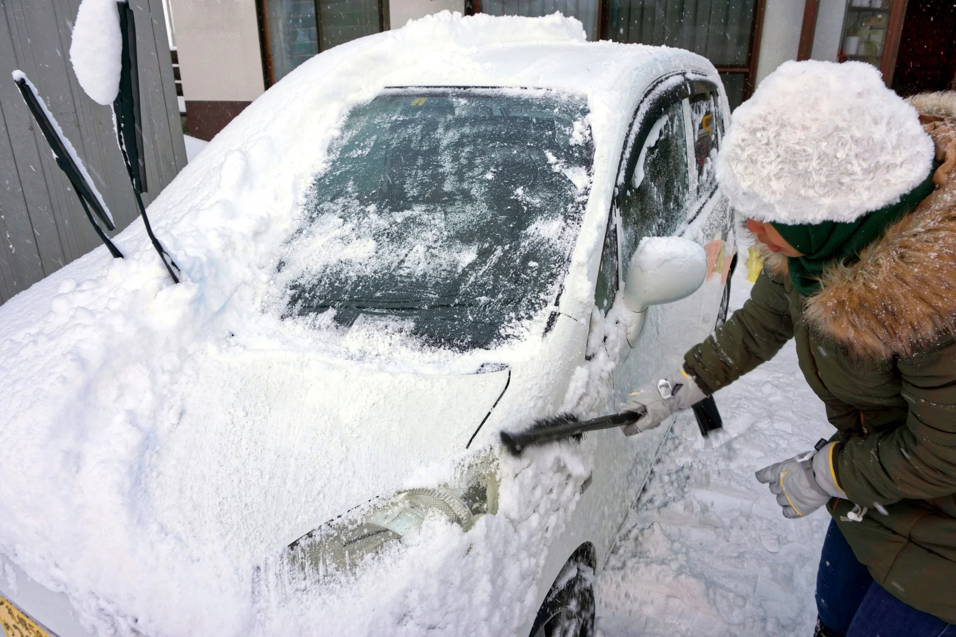 北海道租車,除雪刷,一位女子正在清除車上的積雪